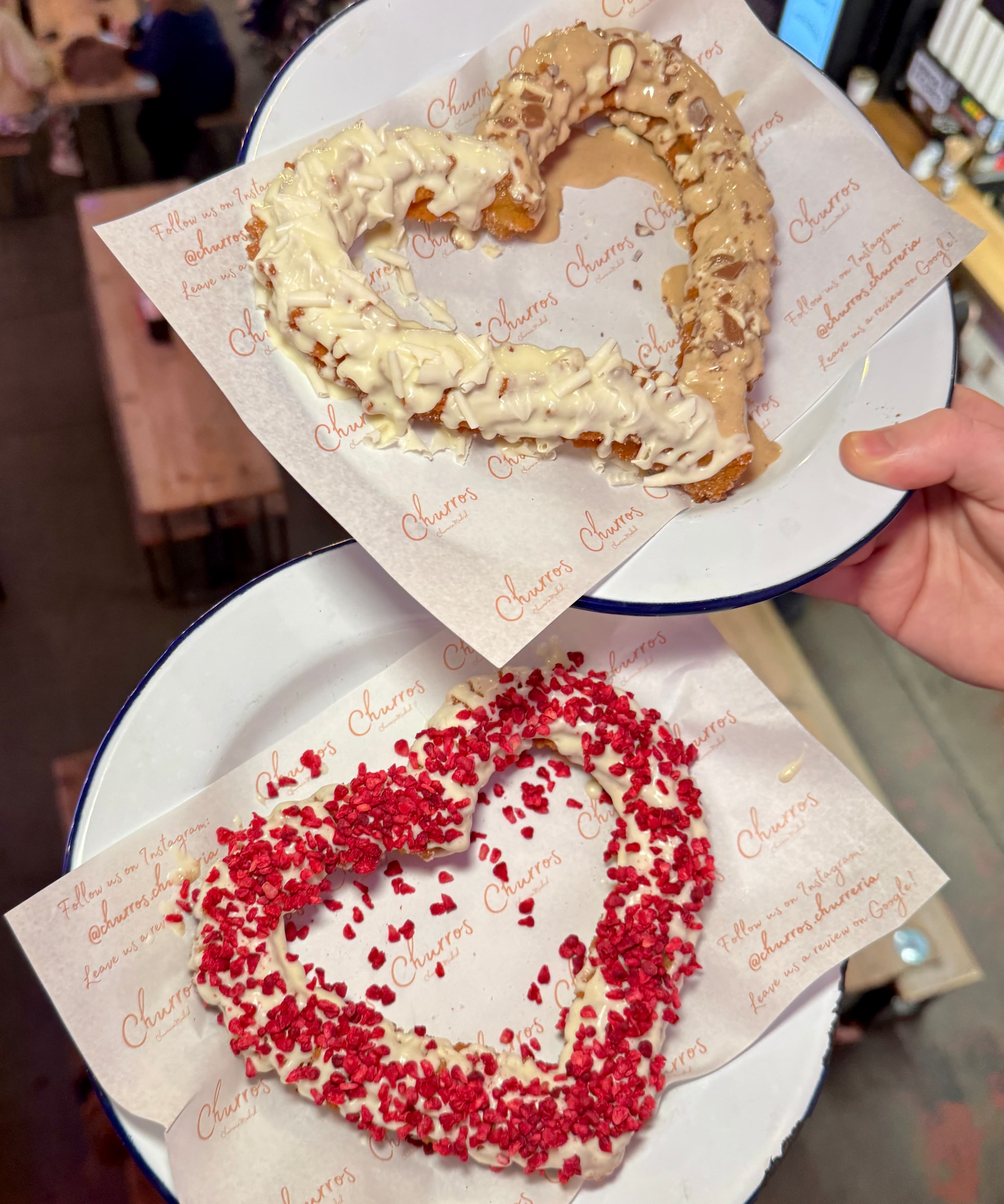 Positive young multiracial friends eating fast food and drinking beer in outdoor cafe